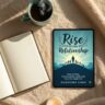 A cozy reading setup featuring a steaming cup of coffee, a candle, open books, and a smartphone displaying the cover of Rise in Every Relationship by Dhirendra Singh. The scene evokes warmth, reflection, and emotional connection — perfectly aligning with the book’s theme of healing and communication.